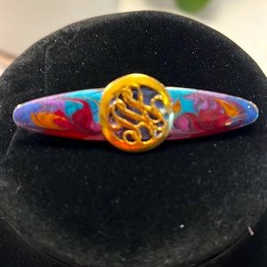 Multicolored brooch with gold round disc.